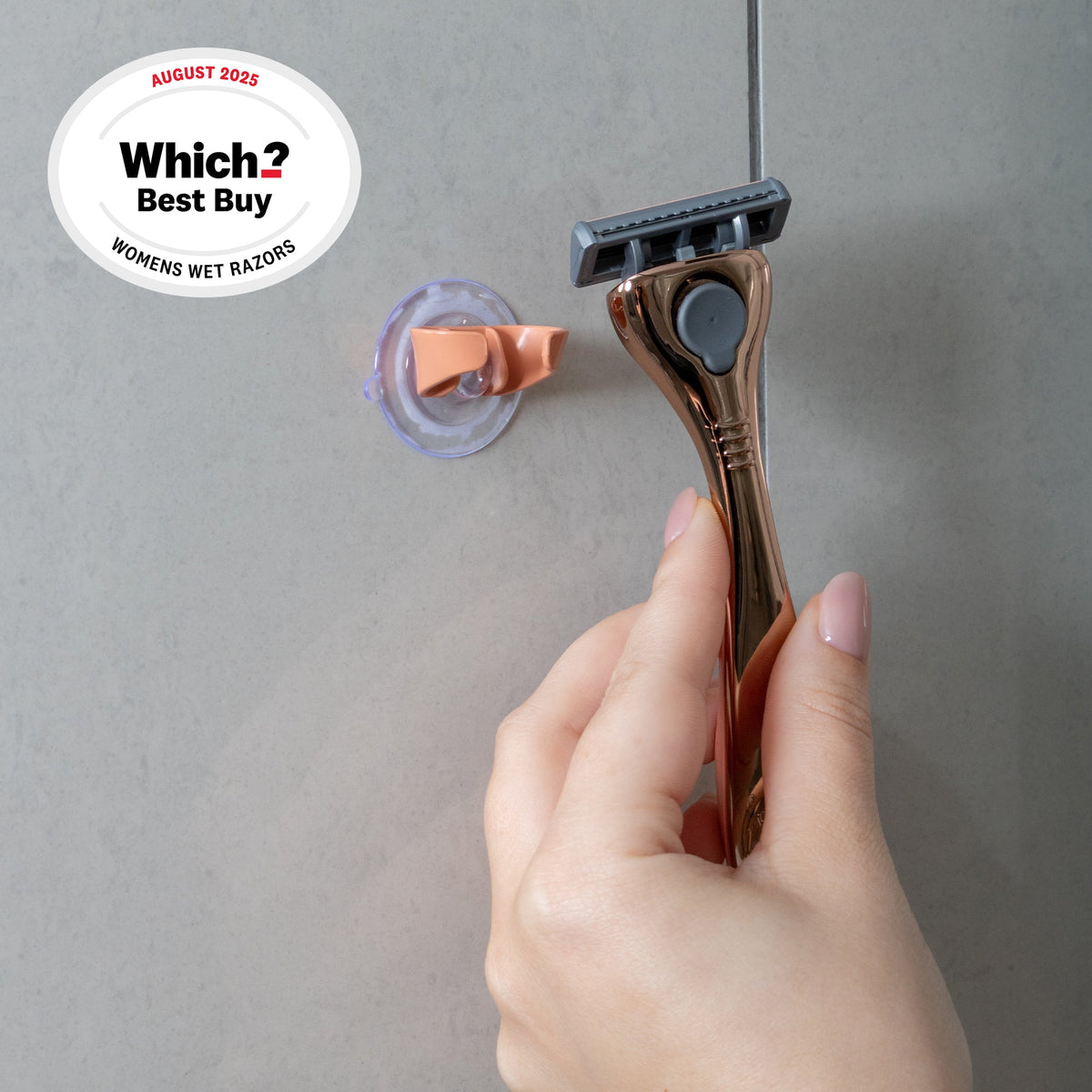 Hand reaching for the FFS Beauty Rose Razor Kit from a suction cup shower holder mounted on grey tiles